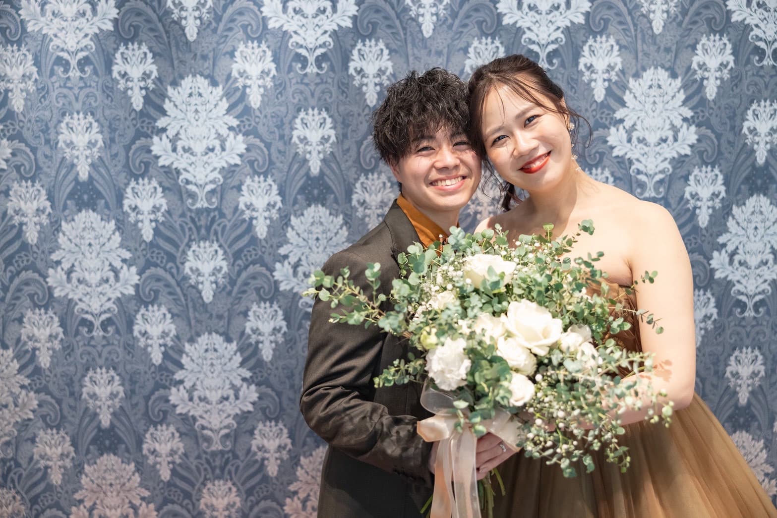 新郎新婦が一緒にブーケを持ち笑顔で写っている写真